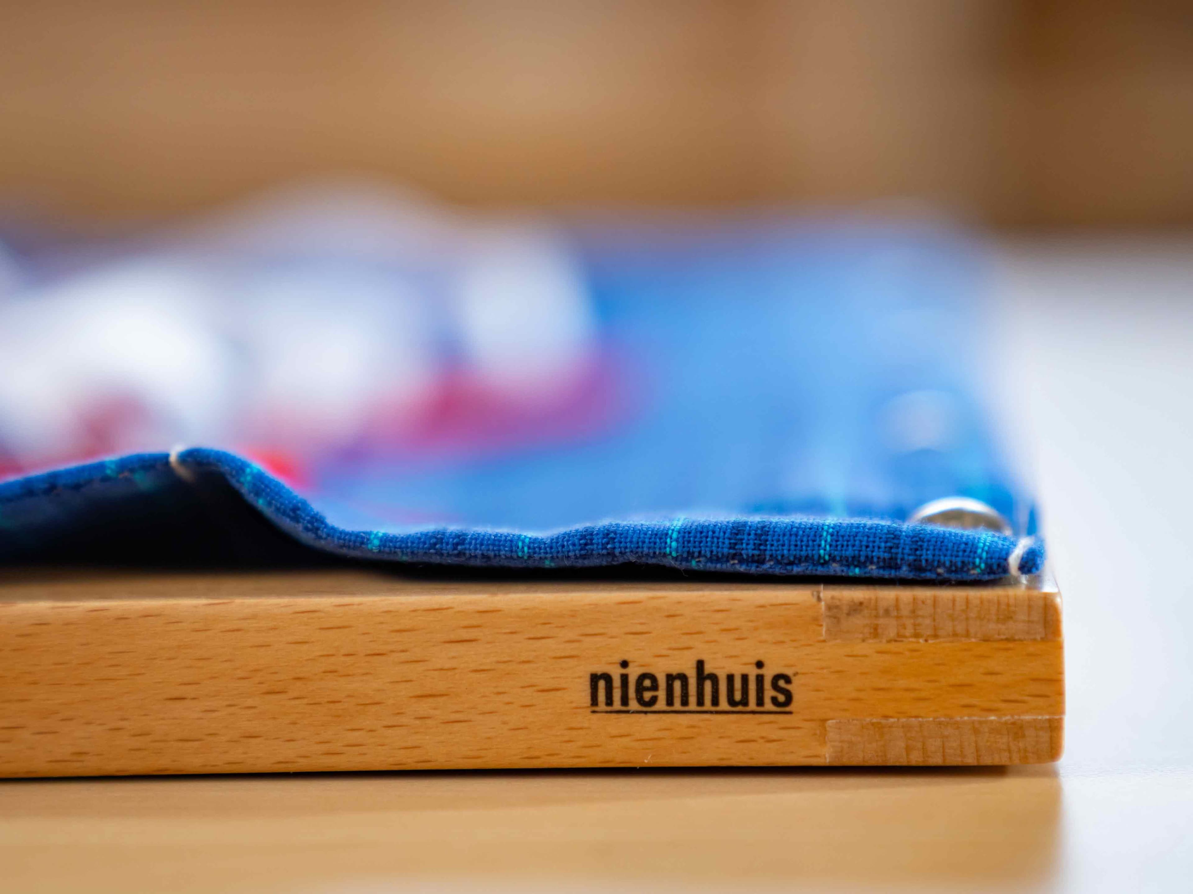 Nahaufnahme eines Nienhuis Kleinkind-Anziehrahmen, mit Betonung auf das Nienhuis-Logo.