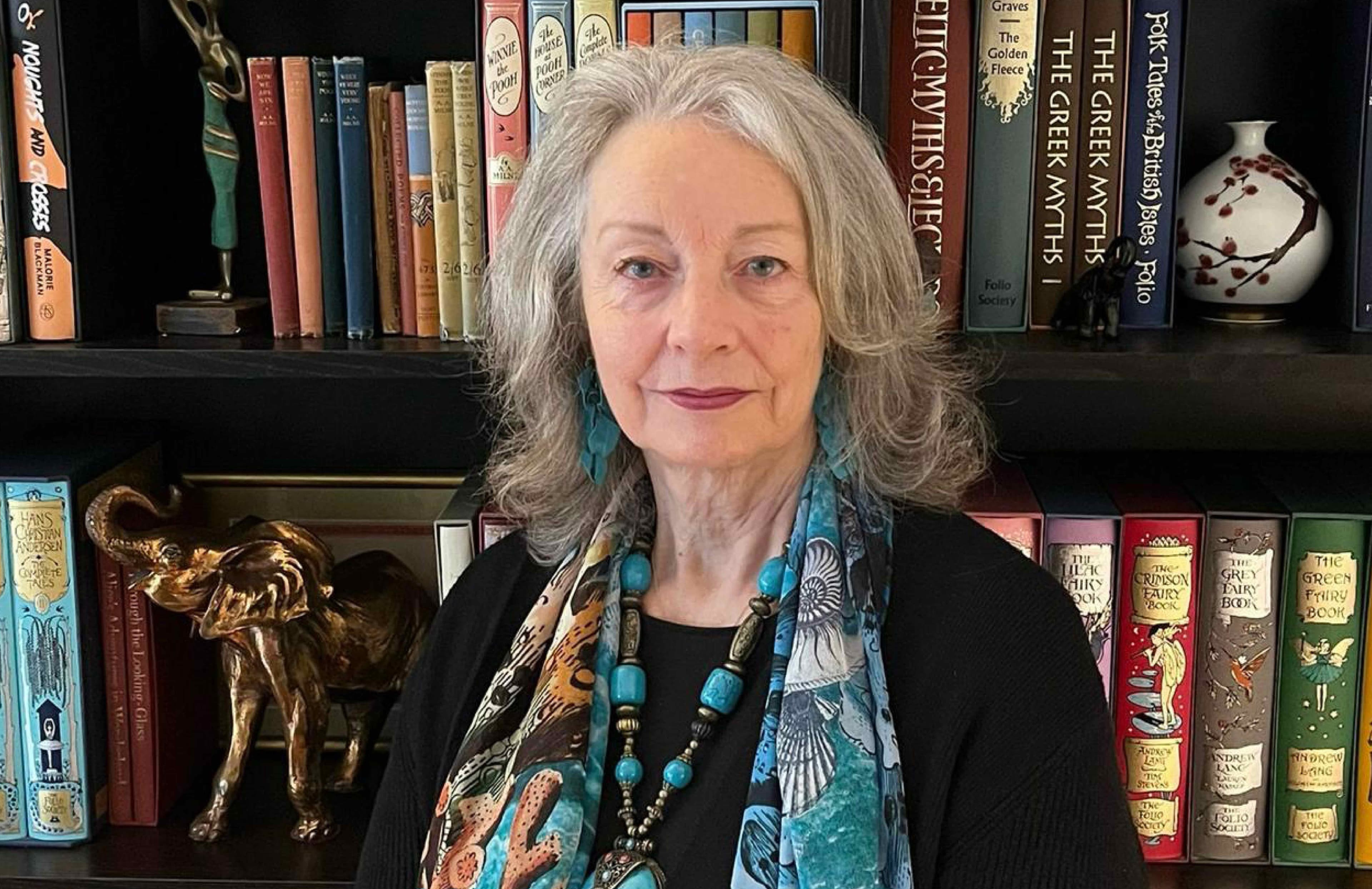 A photo of Lynn Lawrence standing in front of a bookshelf.